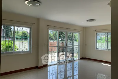 Spacious living room with large windows and garden view, perfect for natural light lovers.