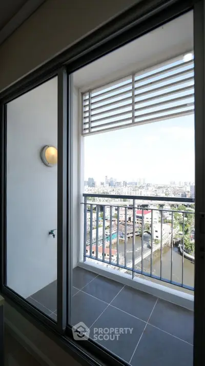 Stunning high-rise balcony with panoramic city and river views, perfect for relaxation and enjoying the skyline.