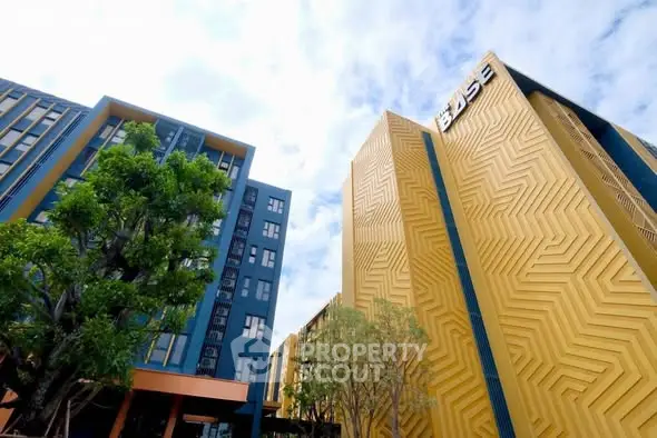 Modern architectural building with unique geometric facade and lush greenery