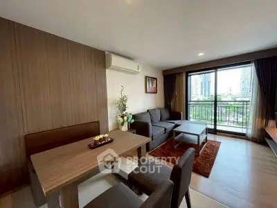Modern living room with city view, featuring cozy seating and dining area.
