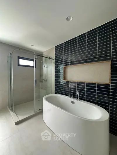 Luxurious modern bathroom with sleek bathtub and glass shower enclosure.