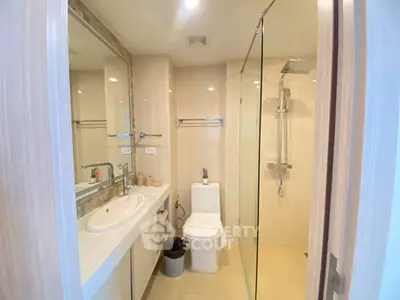 Modern bathroom with glass shower and sleek fixtures in a contemporary apartment.