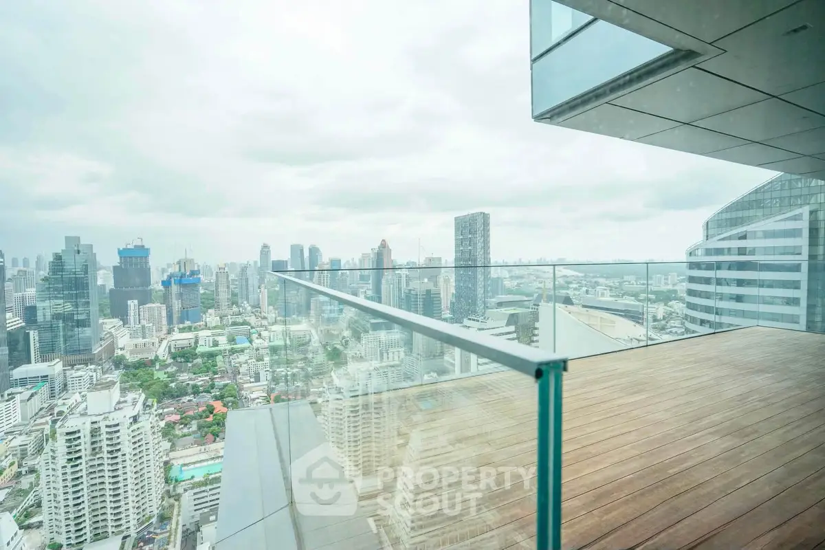 Stunning cityscape view from a modern glass balcony in a high-rise building.