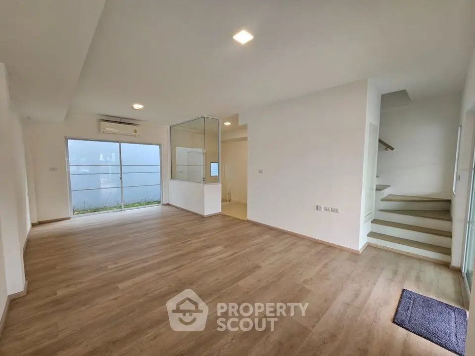 Spacious modern living room with wooden flooring and natural light