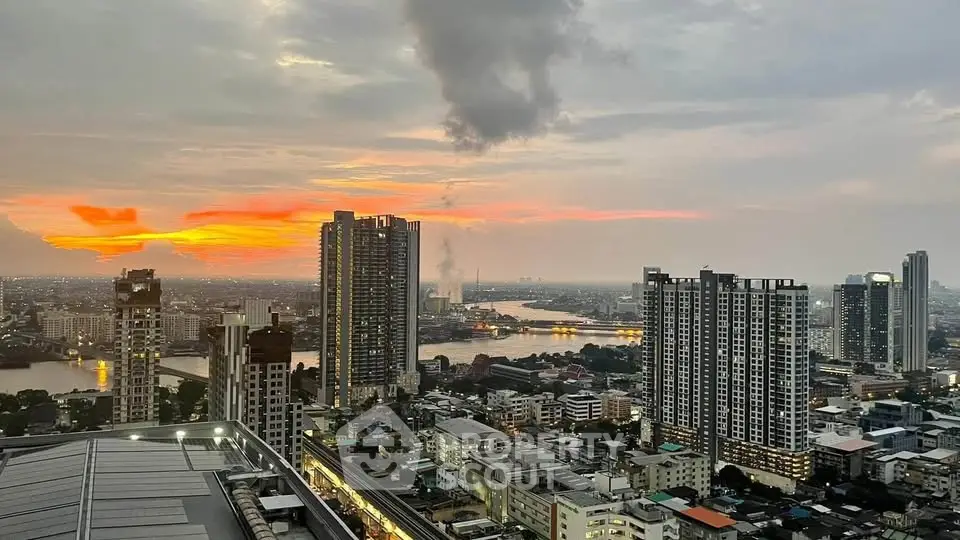 Stunning cityscape view from high-rise building at sunset, showcasing vibrant skyline and river.