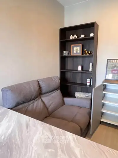 Cozy living room corner with plush sofa and elegant shelving unit.