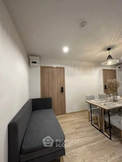 Modern dining area with stylish lighting and cozy seating in a contemporary apartment.