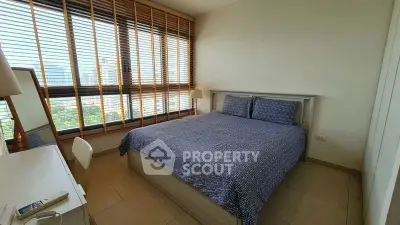 Spacious bedroom with large windows and modern decor in a high-rise apartment.