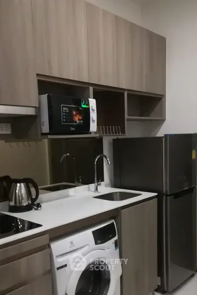 Modern kitchen with sleek appliances and ample storage in a stylish apartment.