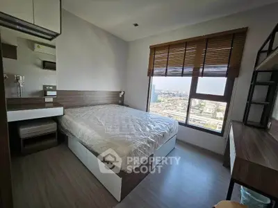 Modern bedroom with city view, featuring sleek design and ample natural light.