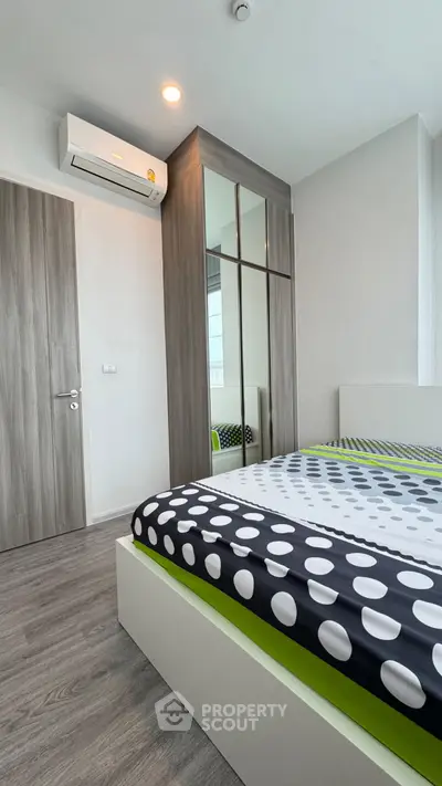 Modern bedroom with stylish decor and mirrored wardrobe