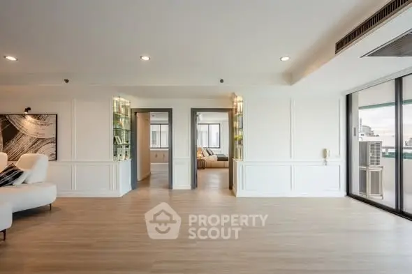 Spacious modern living room with elegant design and large windows offering city views.