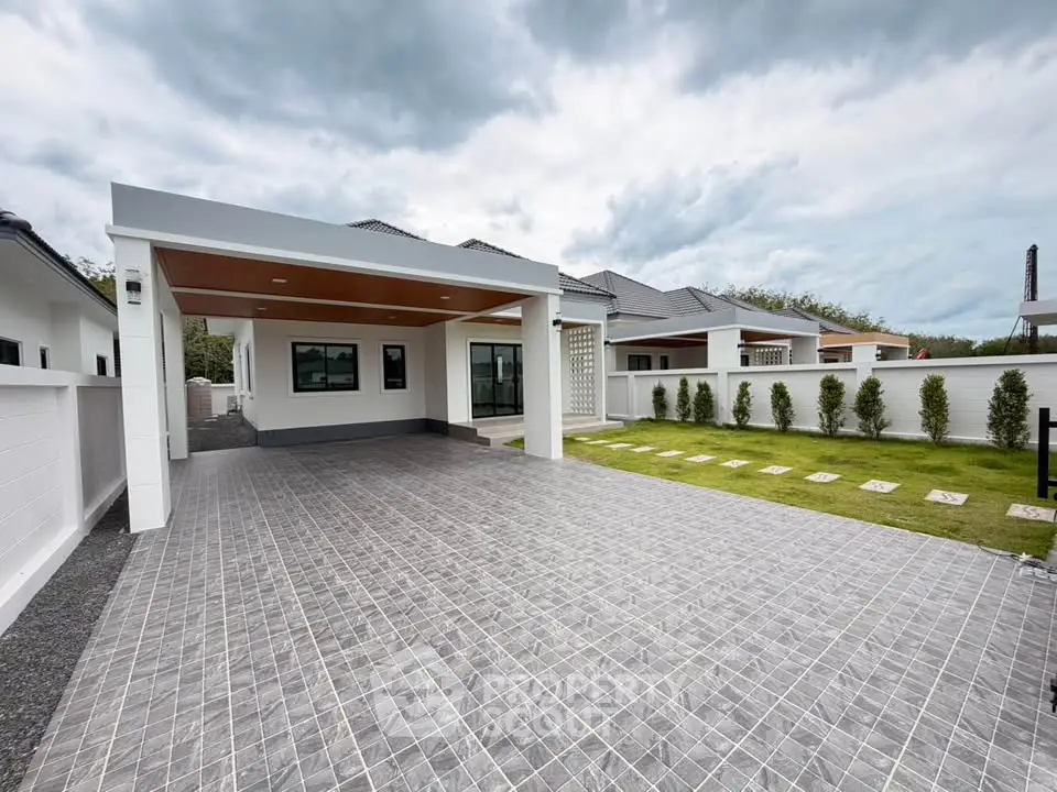 Modern single-story house with spacious driveway and landscaped garden