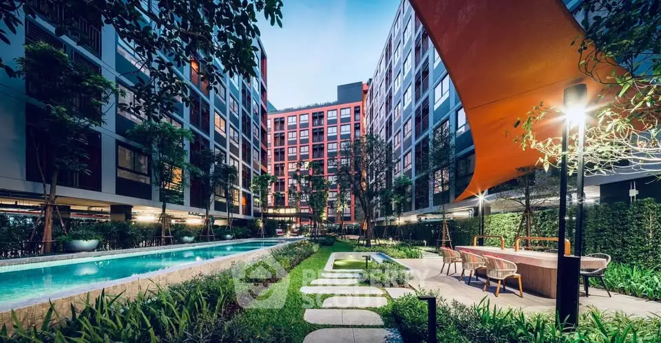 Luxurious modern apartment complex with pool and lush garden, perfect for urban living.