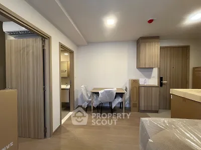 Modern apartment interior with wooden flooring and compact dining area, showcasing a cozy and functional living space.