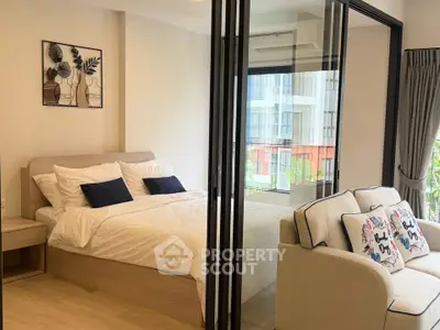 Modern studio apartment with glass partition, cozy bedroom, and stylish living area.