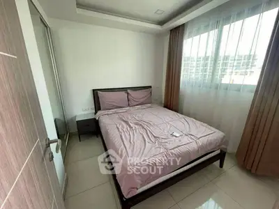 Cozy bedroom with modern decor and large window offering natural light