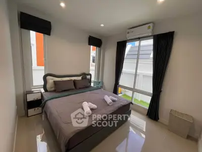 Modern bedroom with large windows and stylish decor in a contemporary home.