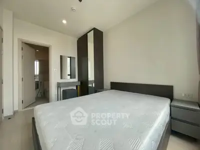 Modern bedroom with minimalist design and ensuite bathroom in a stylish apartment.