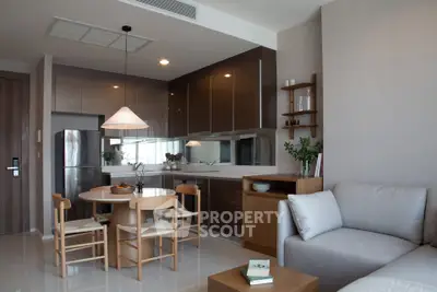 Modern open-layout kitchen and living room with sleek design and cozy seating area.