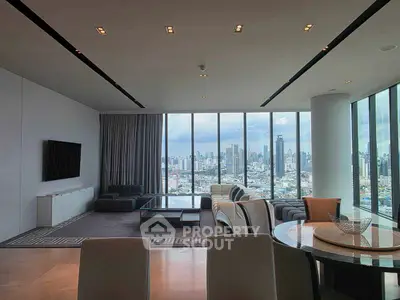 Luxurious living room with panoramic city view and modern furnishings in high-rise apartment.