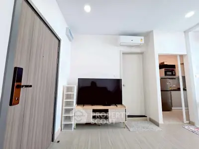 Modern living room with sleek TV setup and air conditioning in a stylish apartment.