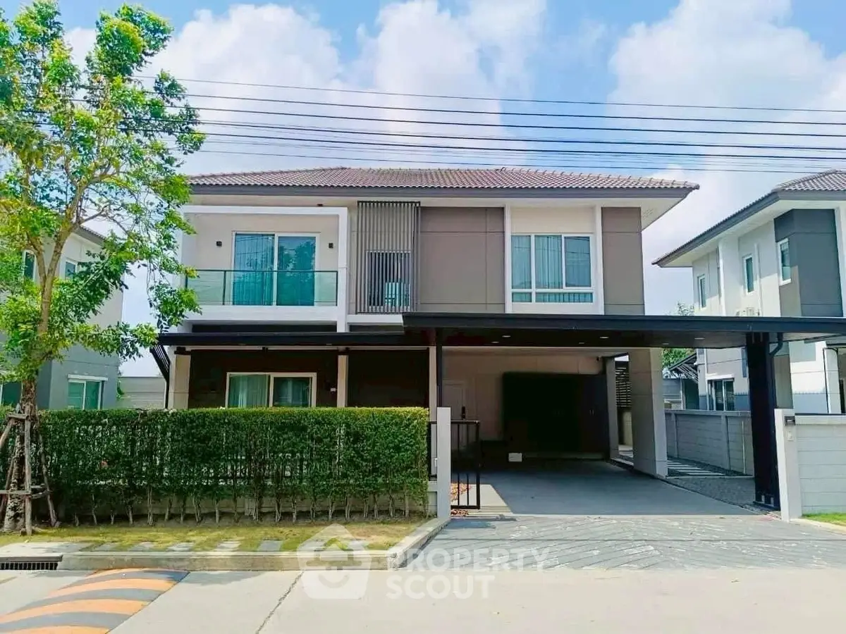 Modern two-story house with spacious driveway and lush greenery in a serene neighborhood.