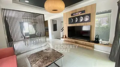 Modern living room with stylish decor and large TV, open layout design.