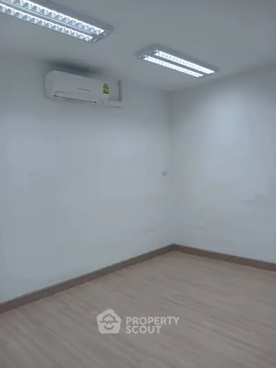 Minimalist room with air conditioning and bright lighting, ideal for office or study space.