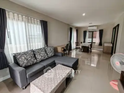 Spacious living room with modern furniture and large windows in a stylish apartment.