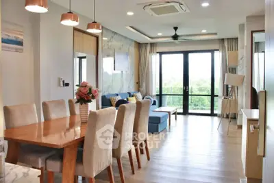 Spacious modern living room with dining area and large windows offering a scenic view.