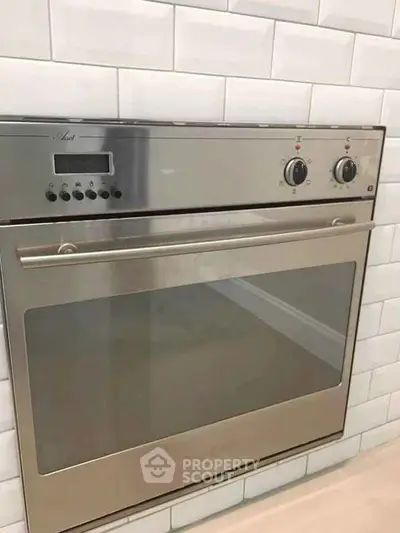 Modern built-in stainless steel oven in sleek kitchen setting.