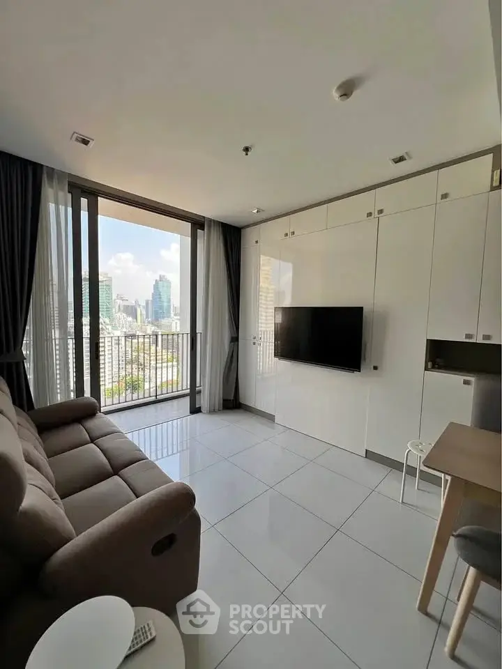 Modern living room with city view, sleek furniture, and large windows in a high-rise apartment.