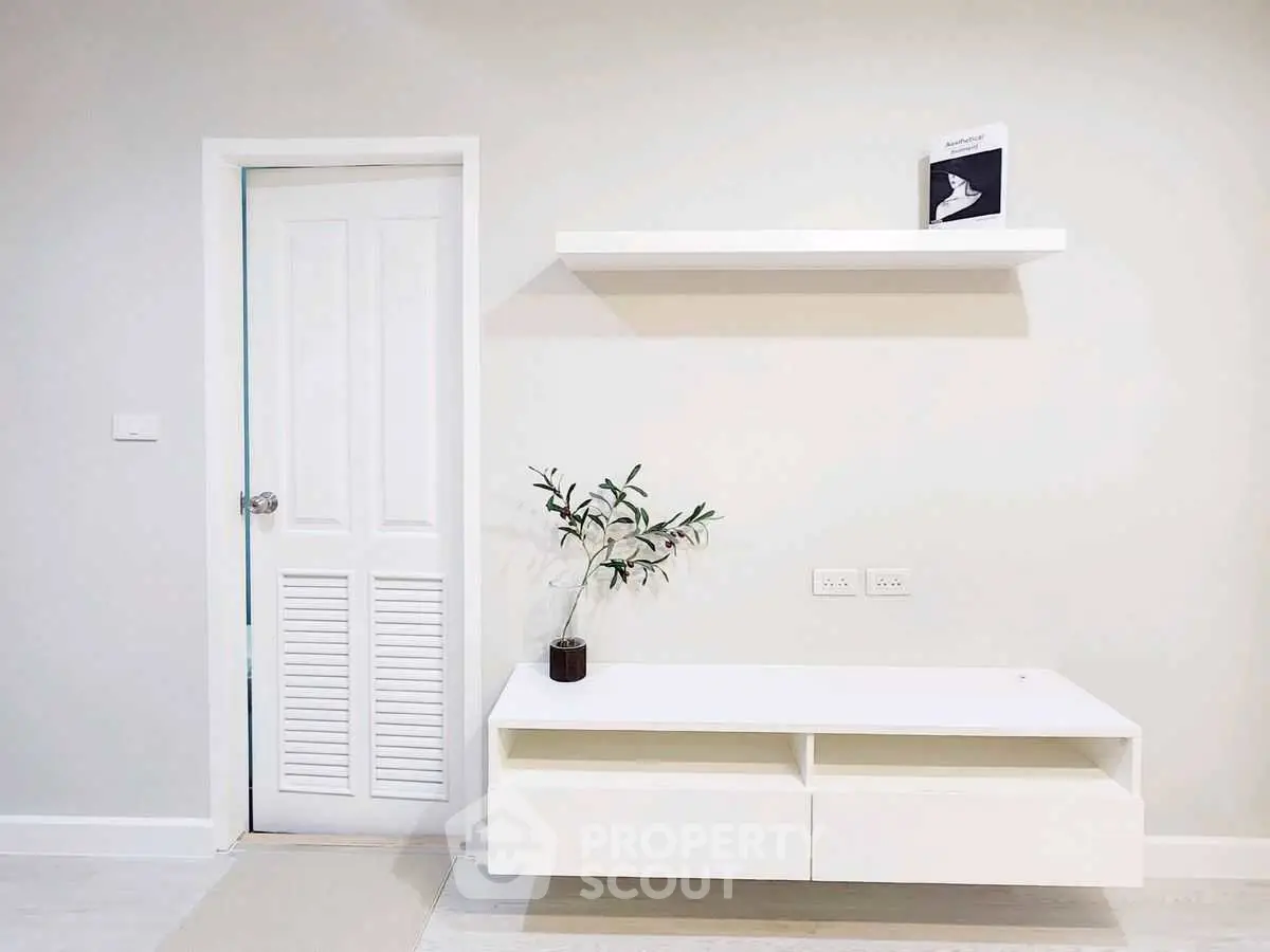 Minimalist interior with white shelving and door, perfect for modern living spaces.