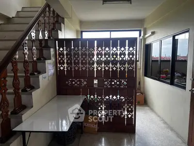Charming interior stairway with decorative wooden railing and natural light, perfect for cozy home ambiance.