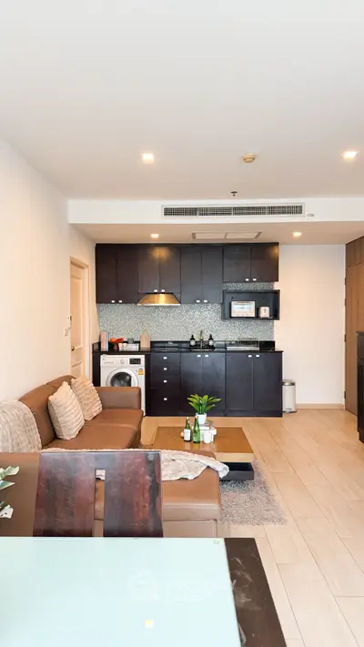 Modern living room with open kitchen and stylish brown furniture