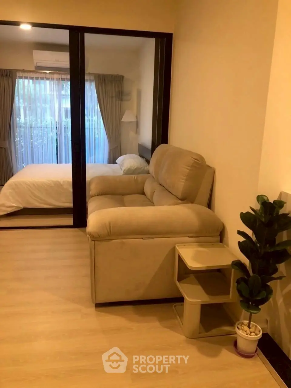 Cozy apartment with a compact living room and bedroom, featuring modern furnishings and natural light.