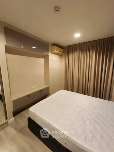 Cozy bedroom with modern design and neutral tones, featuring a comfortable bed and ample natural light.