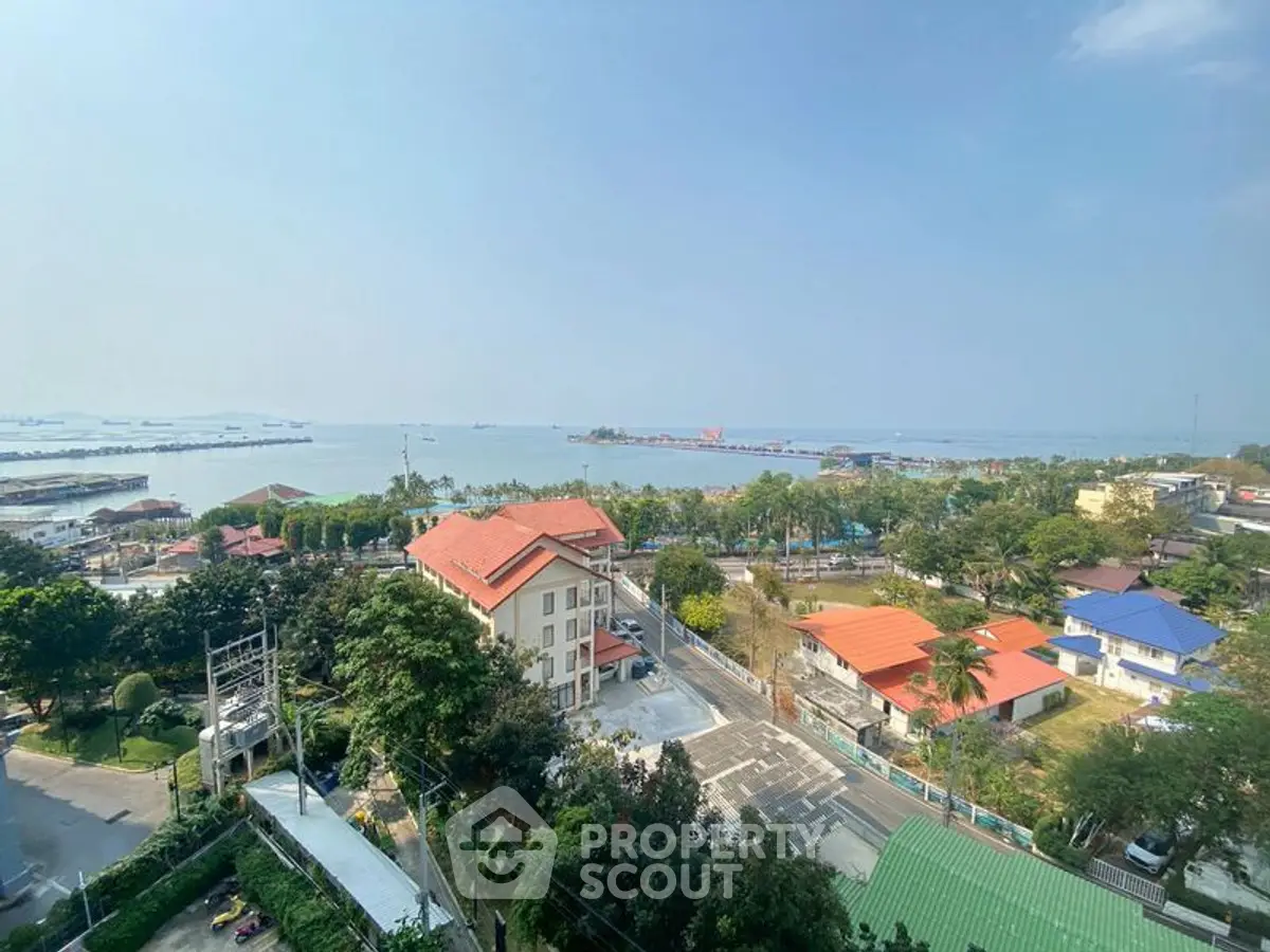 Stunning coastal view from high-rise apartment overlooking serene ocean and vibrant neighborhood.