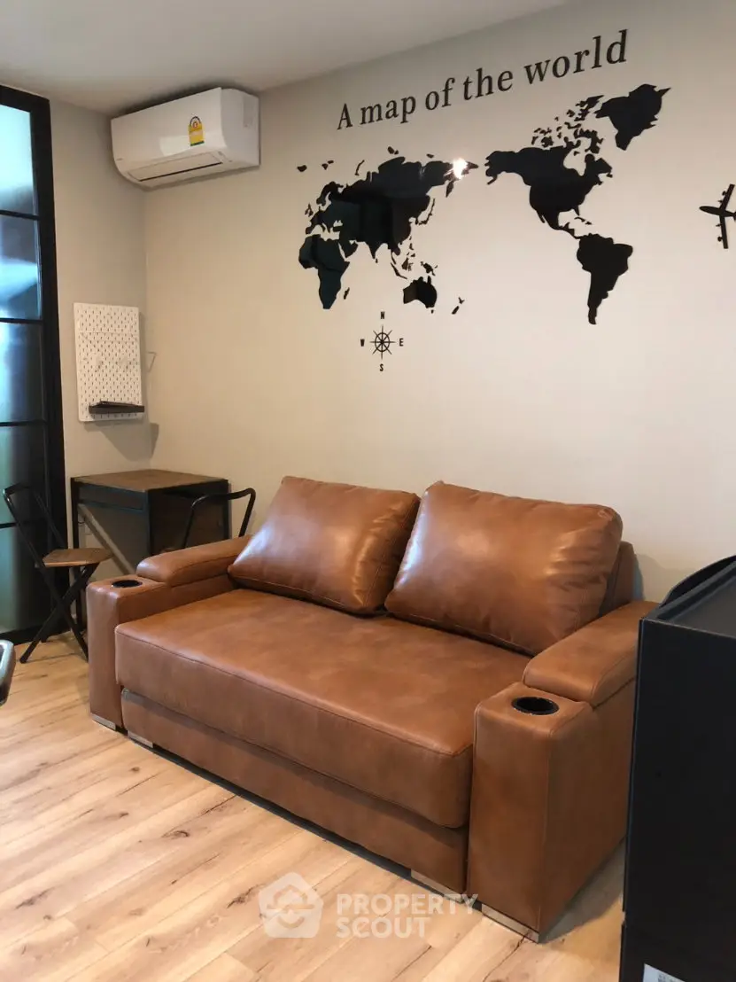 Stylish living room with leather sofa and world map wall art, perfect for modern urban living.