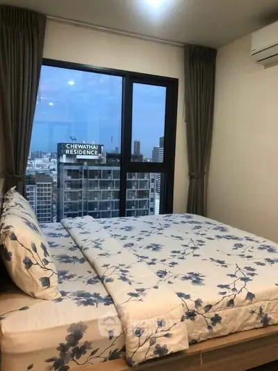 Modern bedroom with city view in high-rise apartment