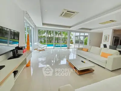 Luxurious living room with pool view, modern furniture, and sleek design.