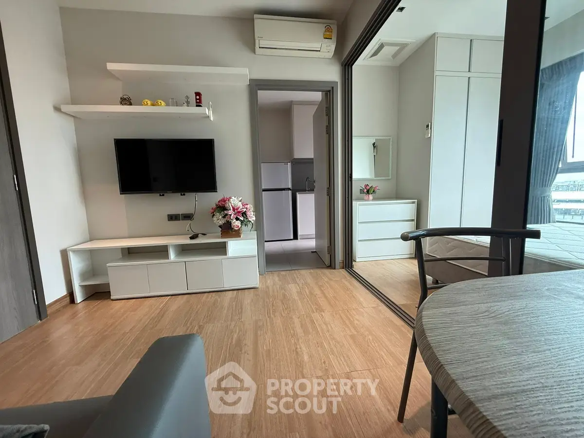 Modern living room with sleek furniture and wooden flooring in a stylish apartment.