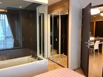 Modern bedroom with glass partition and ensuite bathroom in luxury apartment
