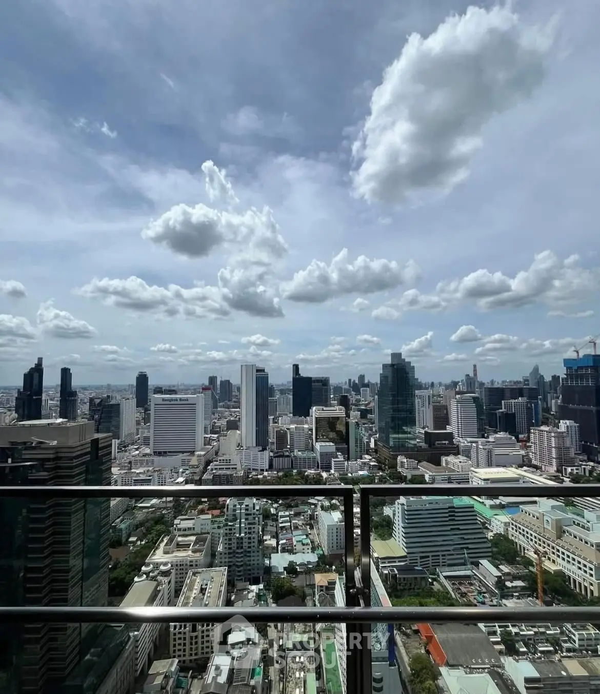 Stunning cityscape view from high-rise balcony with clear skies and modern skyline.