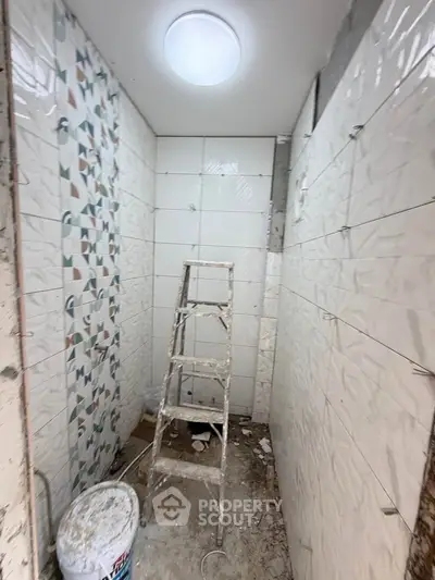 Under-construction bathroom with modern tile design and ladder