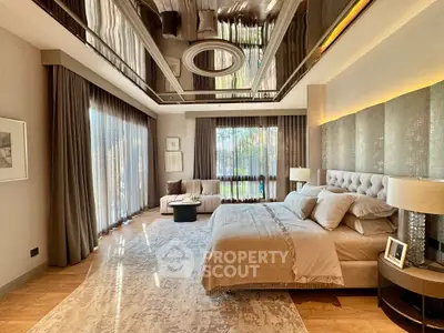 Luxurious bedroom with elegant decor, large windows, and plush furnishings in a modern home.