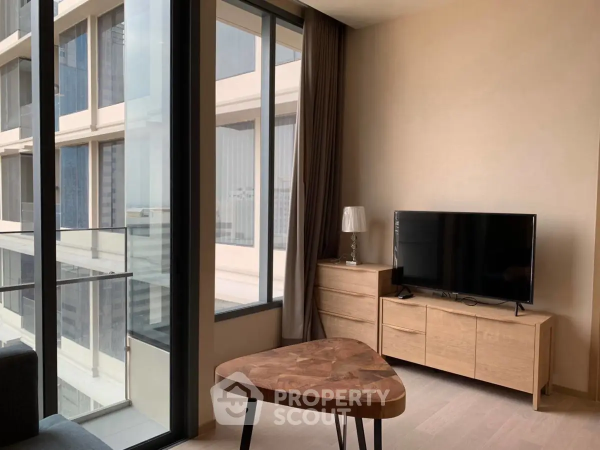 Modern living room with large windows and stylish furniture in a high-rise apartment.