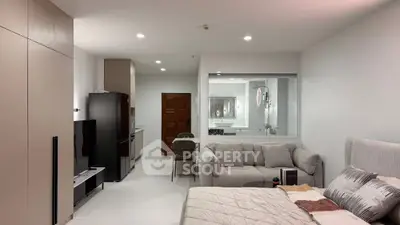 Modern studio apartment with open layout, featuring cozy living area and sleek kitchen design.