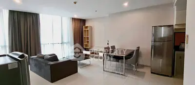 Spacious modern living room with dining area and large windows in a stylish apartment.
